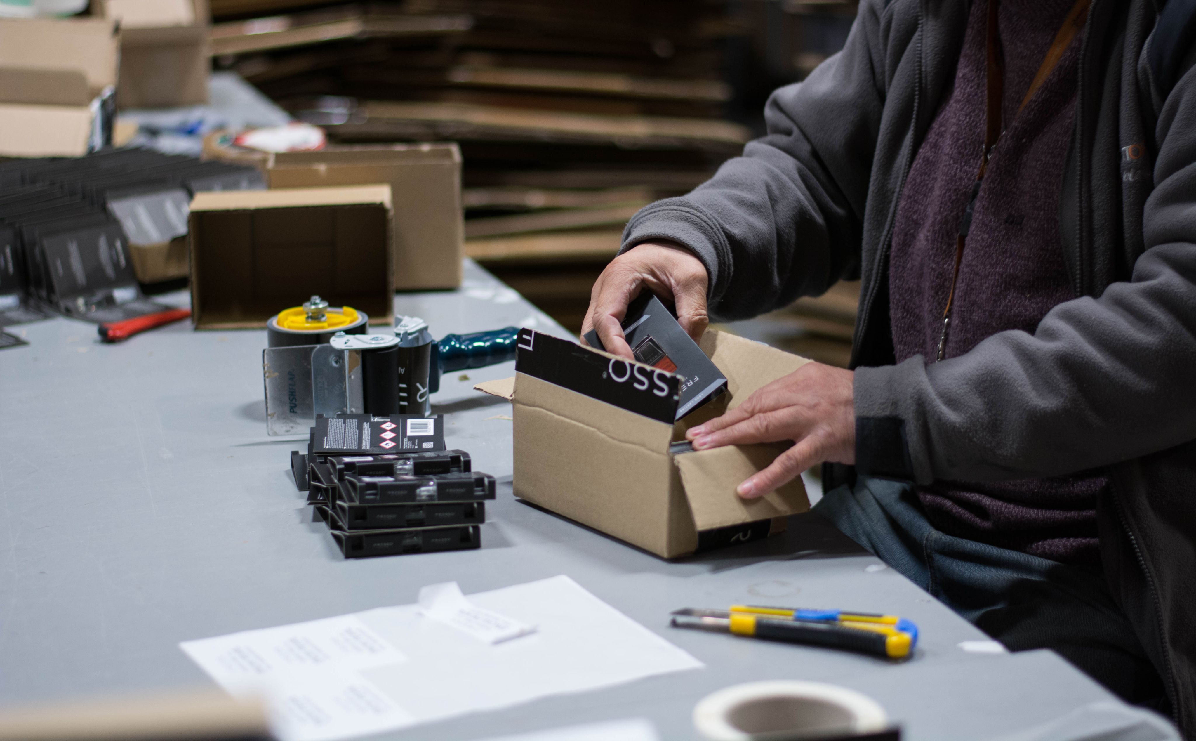 Zdjęcie pracownika przy rozpakowywaniu paczek